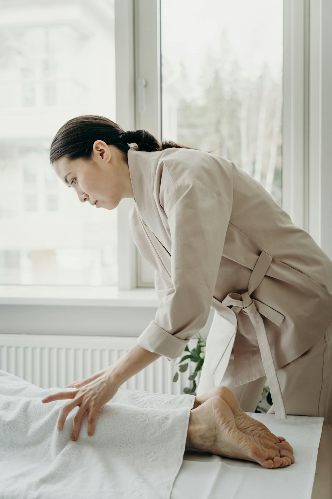 A skilled therapist administers a soothing leg massage in a bright spa room.